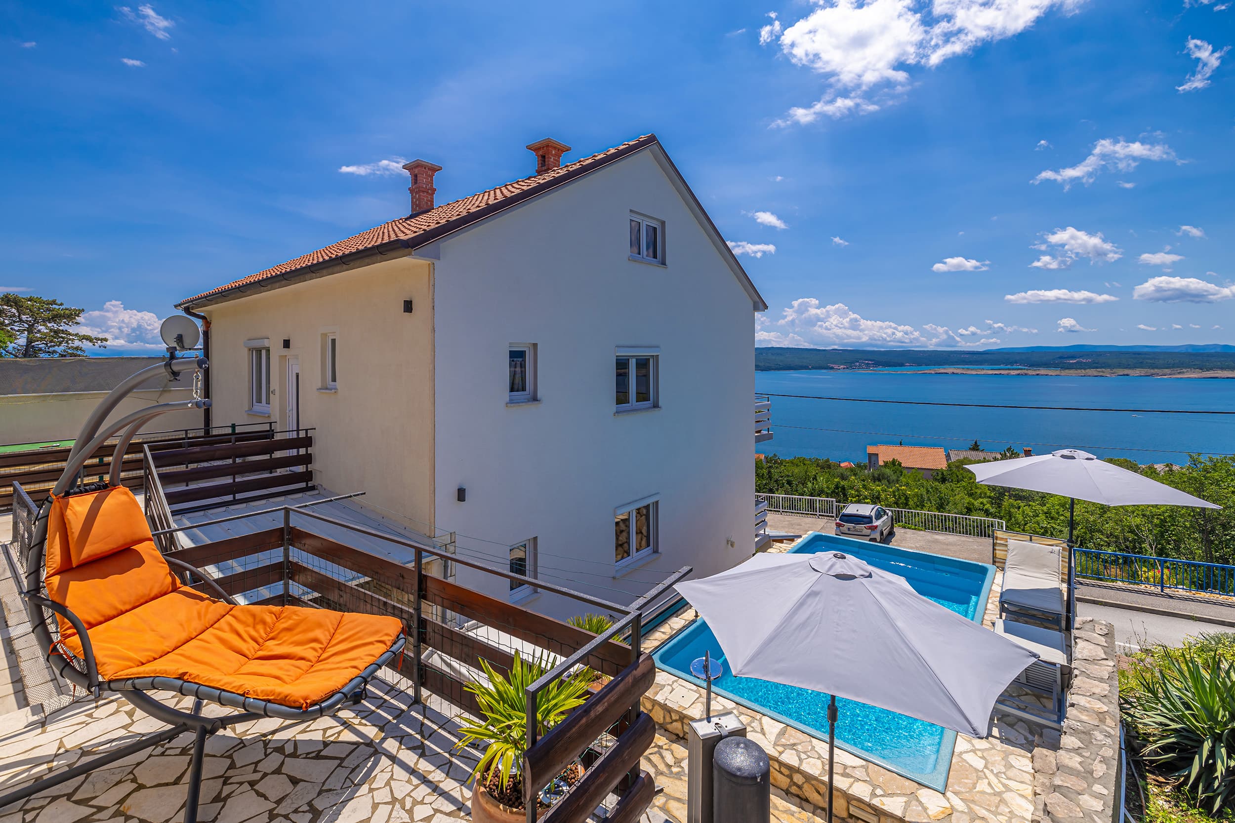 The pool terrace at Guest House Stella, with sun loungers and a view over the Adriatic